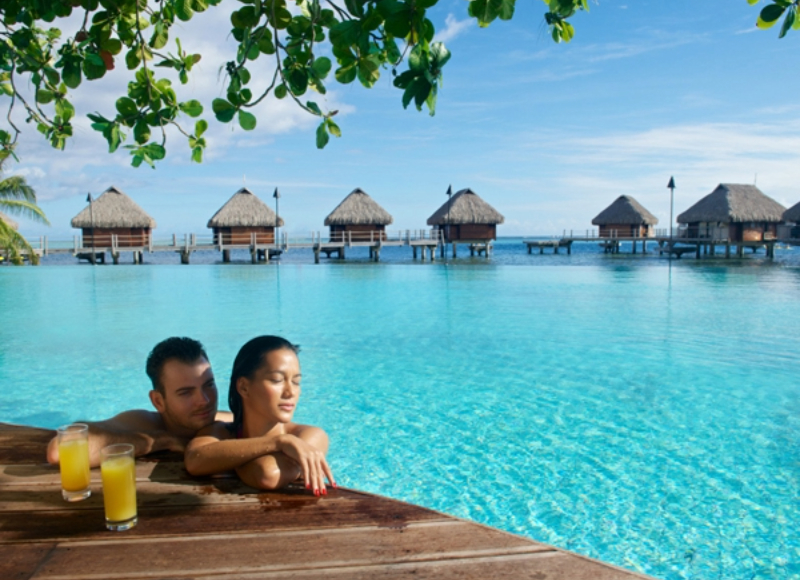 Manava Beach Overwater Bungalow Tahiti Couple with overwater bungalows in the background